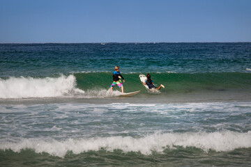 two young australian surfers have fun riding the waves on the beach of Maroubra, Sydney, Australia.