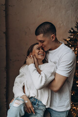 The guy and the girl celebrate the New Year. A loving couple have fun on Christmas in a cozy studio setting. New Year's love story.