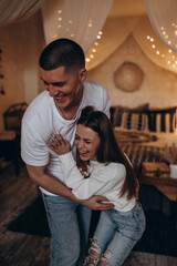 The guy and the girl celebrate the New Year. A loving couple have fun on Christmas in a cozy studio setting. New Year's love story.