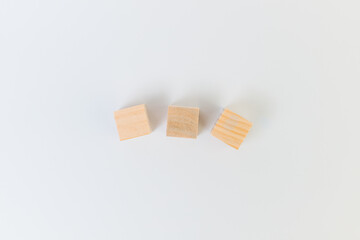 Three wooden cubes on a white background from above