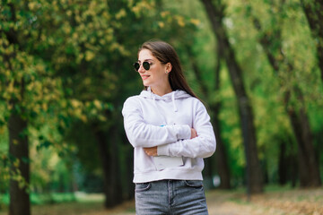 Young woman riding an electric scooter in an autumn park. Green transport, traffic jam problems.