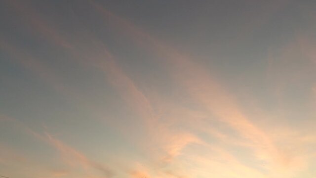 Colorful pastel red pink purple n golden yellow orange clouds or fluffy cirrus cloudscape slowly moved on beautiful sunrise or sunset blue sky in summer sunlight rays, 4k cinemagraphs b-roll TimeLapse