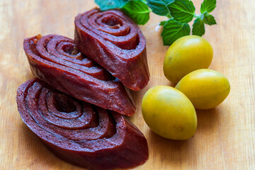 Natural and healthy snack food. Fruit pastille from plum on a wood background. Fruit Marshmallow. Organic food.