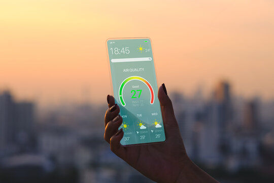 Transparent Smartphone . The Woman Use a futuristic design phone in the city during sunset . air quality design application . future technology and business concept . 