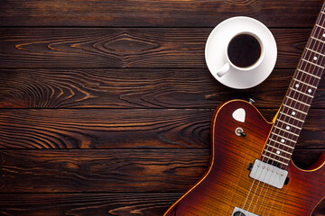 Beautiful electric guitar on with headphones and coffee desktop