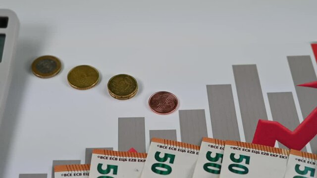 50 euro bills coins and graph with calculator