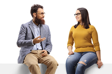 Cheerful bearded man talking to a young female seated on a banner