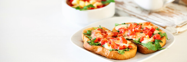 Fototapeta na wymiar Bruschetta or sandwich with tomatoes, mozzarella cheese and herbs. Banner