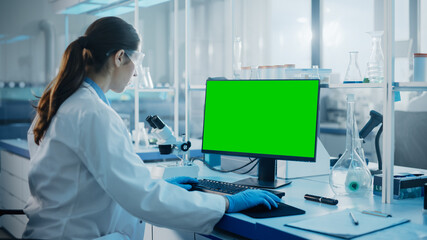 Medical Science Laboratory: Microbiologist Working on Computer with Display with Green Chroma Key...