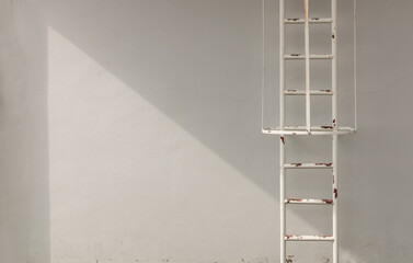 White metal fire escape attached to a wall and leading to the roof of a building. Copy space, No focus, specifically
