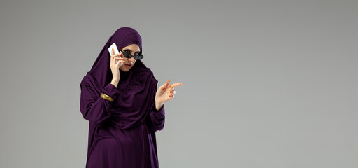 Flyer. Beautiful arab woman posing in stylish hijab isolated on studio background with copyspace for ad. Fashion, beauty, style concept. Female model with trendy make up, manicure and accessories.