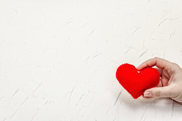 Female hand is holding a homemade red felt heart