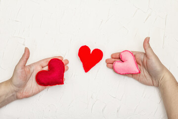 Female hands are holding a homemade felt hearts