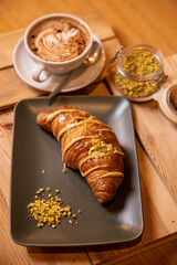 breakfast with creamy brioche, pistachio nuts and cappuccino