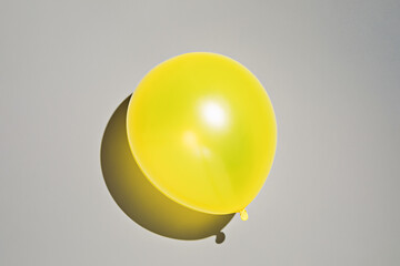Yellow balloon on gray background. Photo in colors of the year 2021