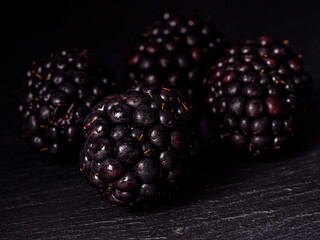 Overhead shot of blackberries on black background.