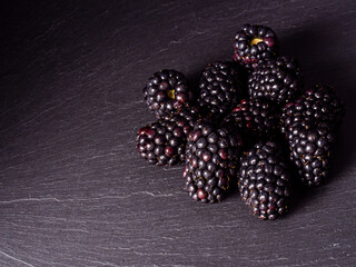 Overhead shot of blackberries on black background.