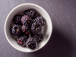 Overhead shot of blackberries on black background.