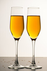 Two glasses of champagne, wine on a gray background. Alcoholic drink: champagne, beer, white wine. New year and Christmas background. Valentine's Day. Vertical photo