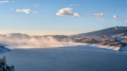 morning fog over mountain lake at foothills of Rocky Mountains - Horsetooth Reservoir in northern Colorado, winter scenery with fresh snow