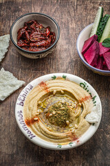 Pumpkin hummus with fresh vegetables on a dark wooden background