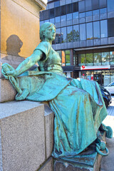 Fototapeta na wymiar Sculpture of a woman sitting at the foot of the monument with a hammer