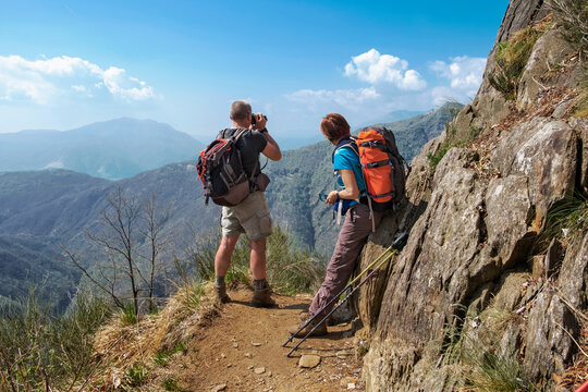 Couple of hikers taking picture and looking the beautiful panorama of  the wild Val Grande National Park, Europe, Piedmont, Italy.