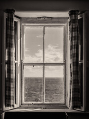 Sea View Out an Old Irish Window, with Shutters and Curtains in Black and White