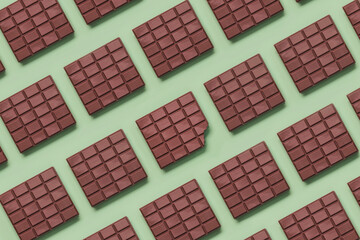 Geometric pattern made with chocolate bars and in the center a bitten tablet