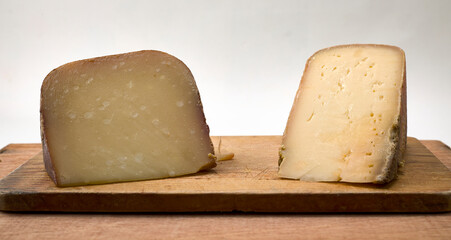 Dos trozos de queso francés sobre una tabla de madera