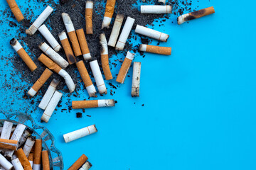 Cigarettes buds with ashtray on blue background.