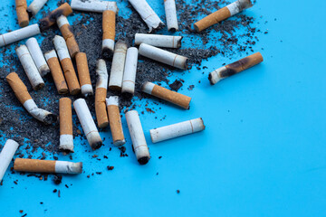 Cigarettes buds with ashtray on blue background.