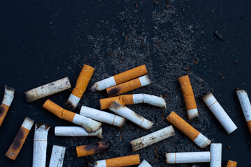 Cigarettes buds with ashtray on dark background.