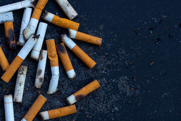 Cigarettes buds with ashtray on dark background.