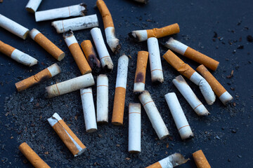 Cigarettes buds with ashtray on dark background.