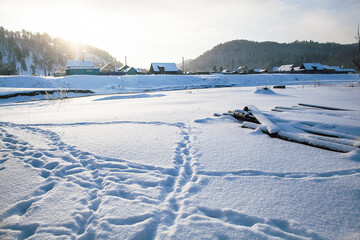 Obraz premium tire tracks in the snow, winter road, empty road in winter goes far to the horizon, covered with snow path, winter landscape