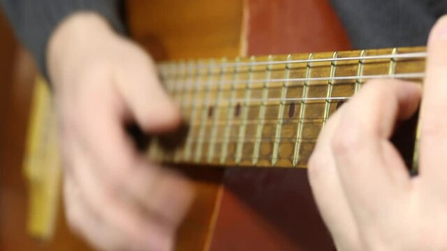 A man plays a six-string acoustic guitar. Plays a fight, takes chords.