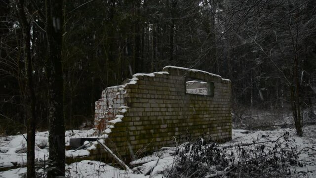 Ruins of a destroyed old building in a snowy forest