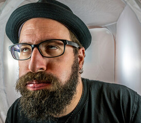 A bearded and annoyed man with empty eyes