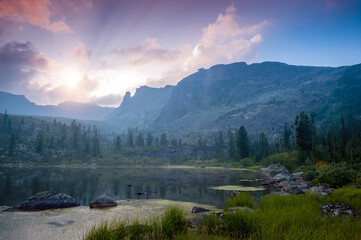 Taiga. Lake and mountains at dawn with beautiful clouds.