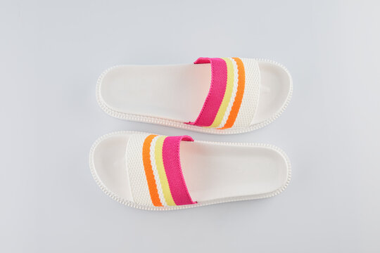 Pair of colorful multicolored rainbow flip flops or sandals on pastel background.