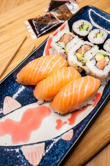Sushi and makis served in a Japanese dish on a wooden background
