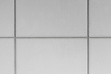 White tiles and gray joints on the wall