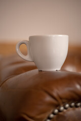 Taza de café sobre un sofá marrón