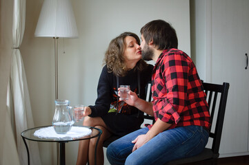 Handsome bearded man dressed in lambersexual style clothes is hugging her young woman in black warm dressed during celebration St. Valentine Day