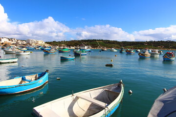 Fototapeta na wymiar Marsaxlokk, un village charmant maltais avec des bateaux colorés