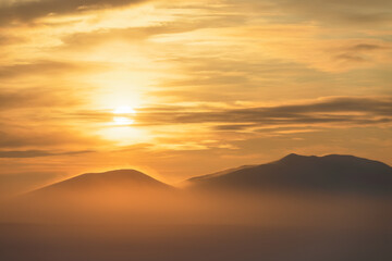 Winter arctic landscape. Beautiful sunset over the tundra and the snow-capped mountain. Nature of Siberia and the Russian Far East. Cold frosty winter weather. Chukotka, Far North of Russia, Arctic.