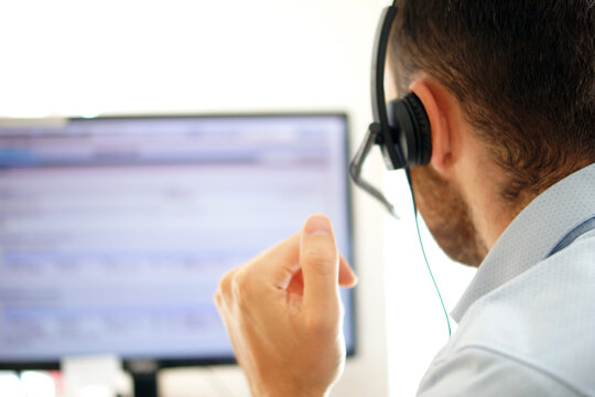 Male call center agent in headset consult client