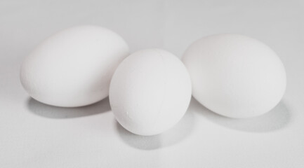 Three white eggs on white background, healthy eating from poultry