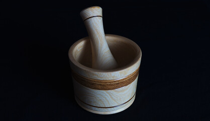 Beautiful grinding mortar made of wood on a black background, used for grinding food